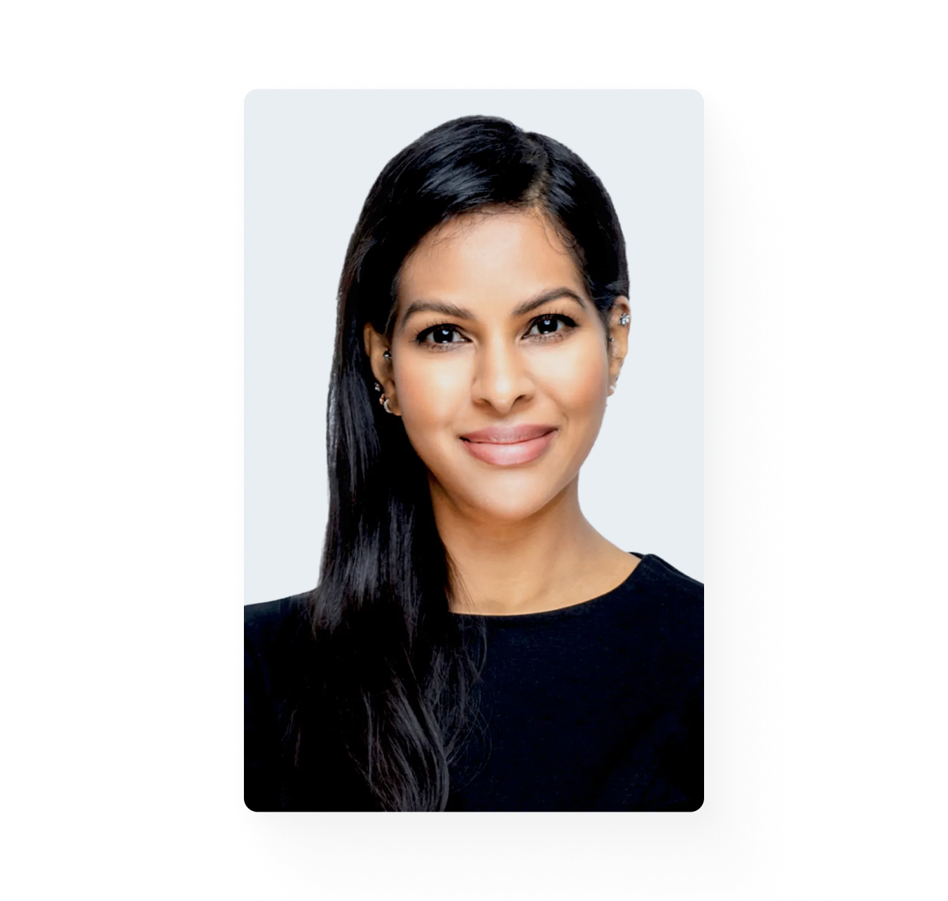 Young woman with long dark hair is smiling and looking at the camera.