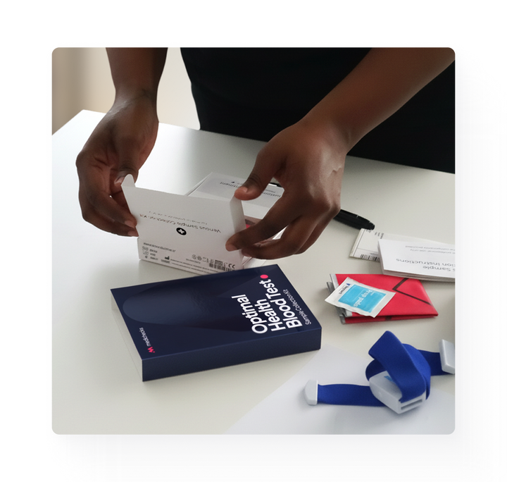 Person opening a box containing medical supplies on a white surface