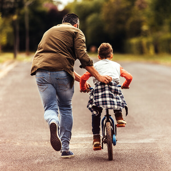 Man teaching his son how to ride a bike