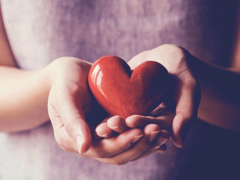 Woman holding a ceramic red heart in her hands
